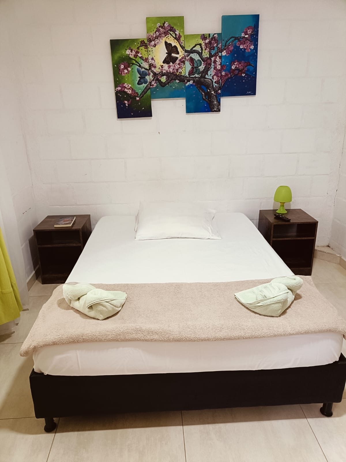 Habitación de Nirvana 3 con cama doble y cuadro de colores